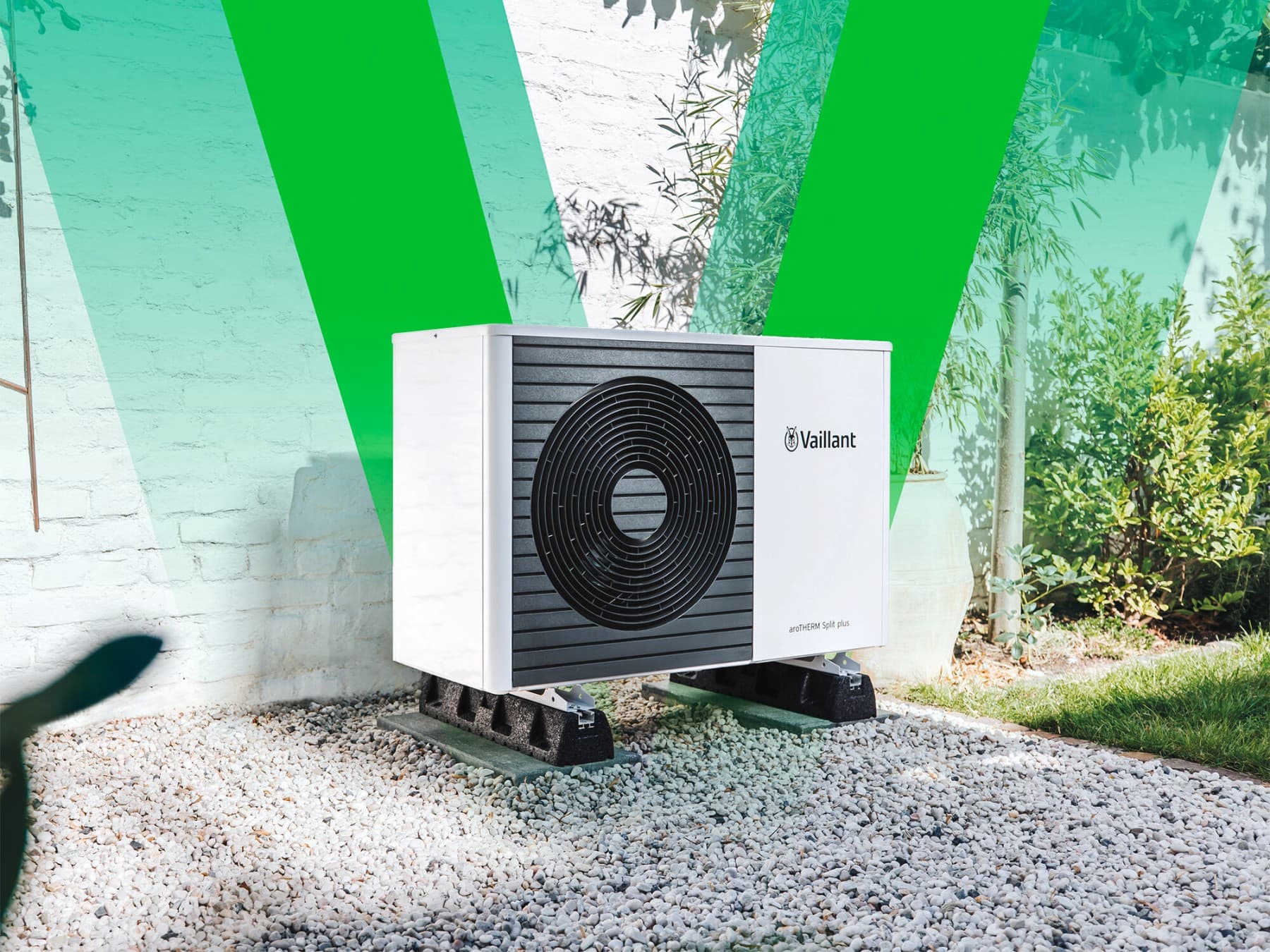 Vaillant toplotna pumpa stoji ispred zida u vrtu