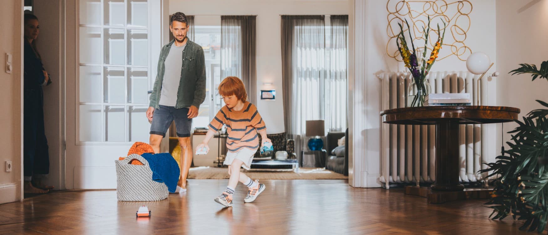 Otac gleda svog sina kako se igra u dnevnoj sobi