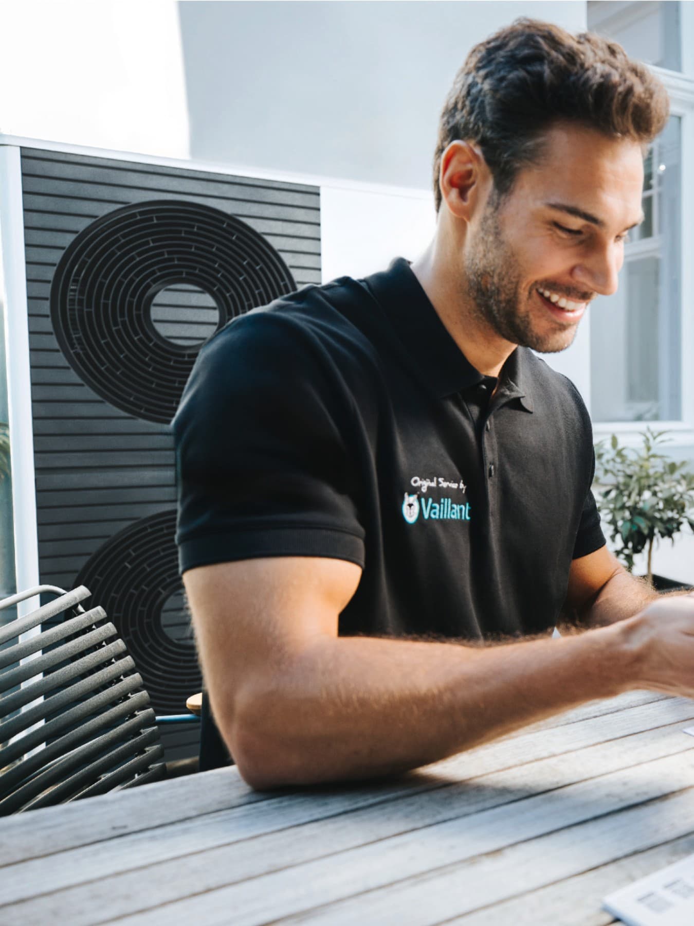 Vaillant instalater sa pametnim telefonom u ruci i kupac koji sjedi pored njega